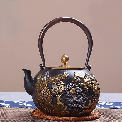 Close-up of phoenix and dragon gold motif on cast iron teapot