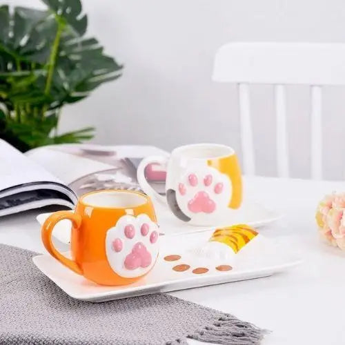 Cat paw tea cup with red paw pad details on a saucer, lid beside it