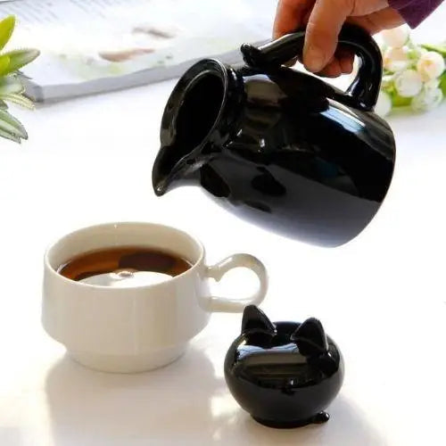 Pouring tea from cat teapot into cup