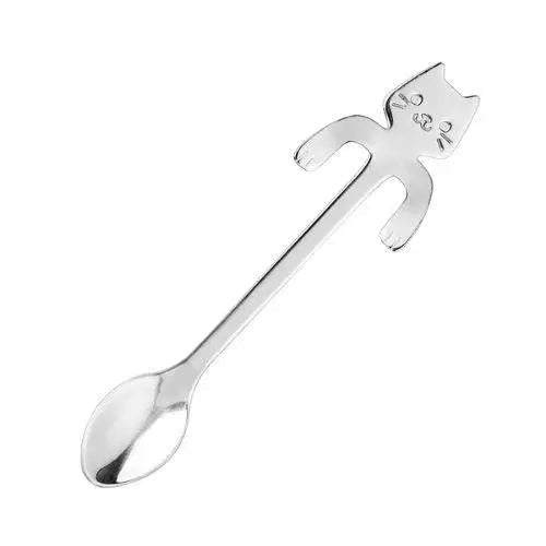 Cat teaspoon resting across a white teacup with brewed tea