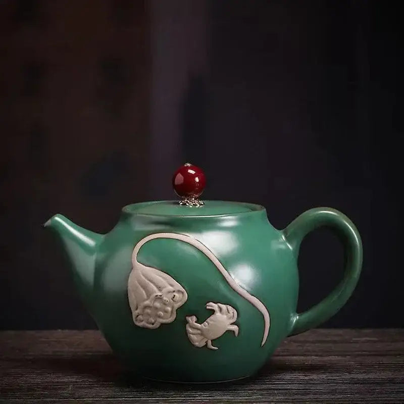 Green ceramic teapot for one on wooden table