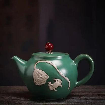 Green ceramic teapot for one on wooden table