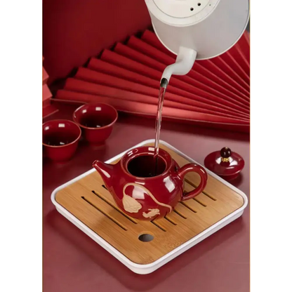 Ceramic teapot for one with tea leaves and cup