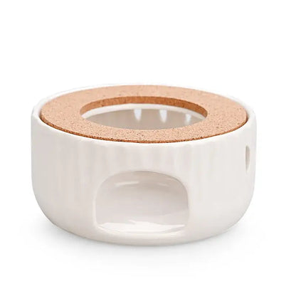 Ceramic teapot warmer with cork base placed on wooden table, lifestyle shot
