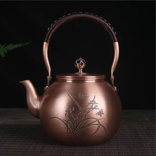 1.5L Chinese copper teapot, hand-engraved butterfly decoration, side view showing motif detail