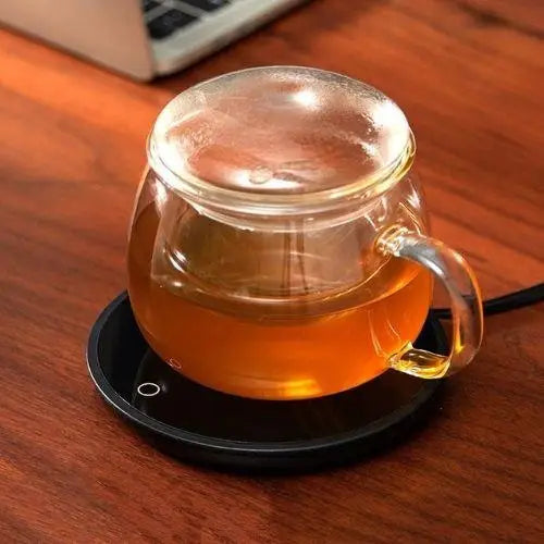 Classic mug warmer on desk with tea cup