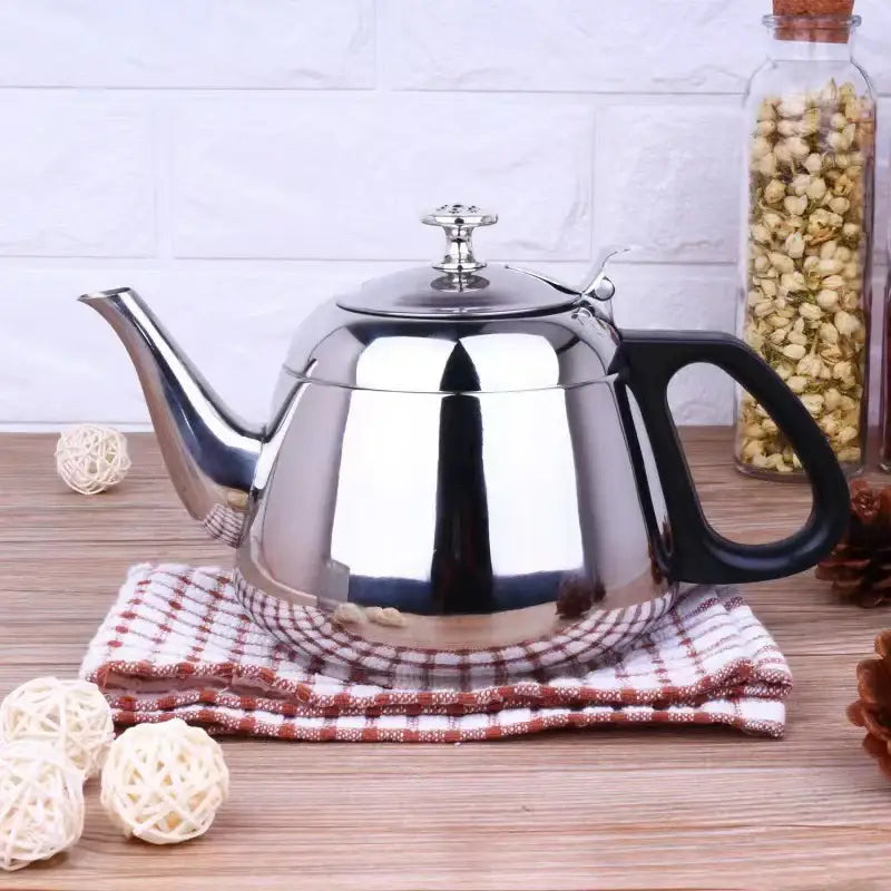 Stainless steel teapot heating on induction stovetop