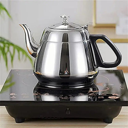 Stainless steel induction teapot pouring brewed loose-leaf tea into cup