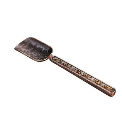 Copper tea spoon with red background