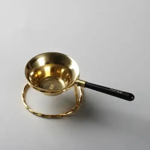Copper tea strainer on a wooden table