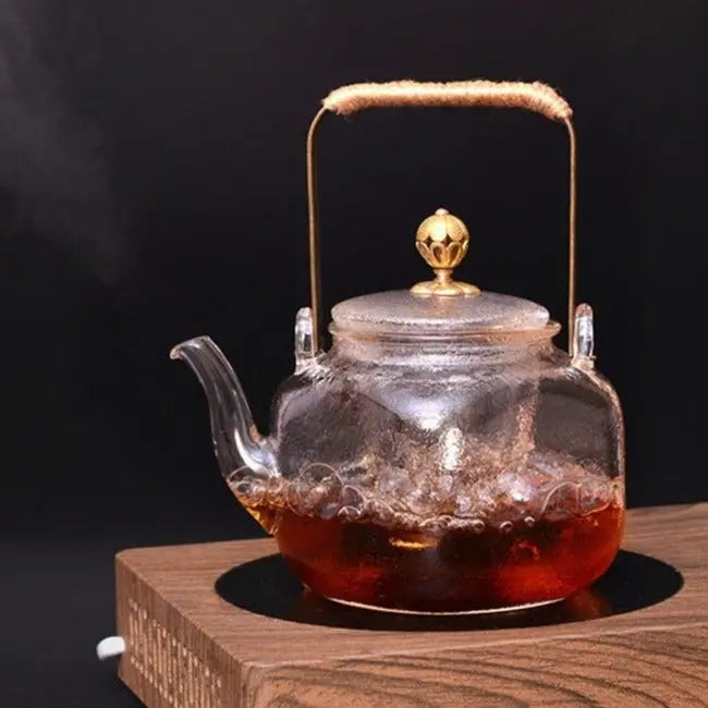 Chinese-style copper teapot with round body and arched handle on wooden table