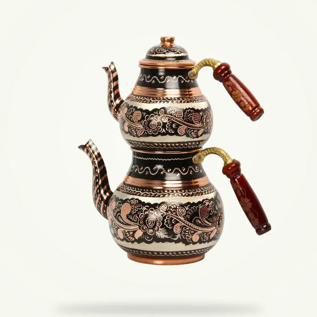Copper Turkish teapot with hand-engraved floral design, front view on plain background