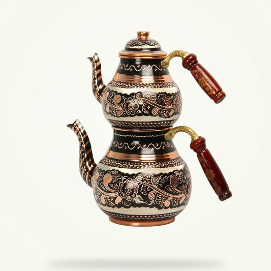 Copper Turkish teapot with hand-engraved floral design, front view on plain background