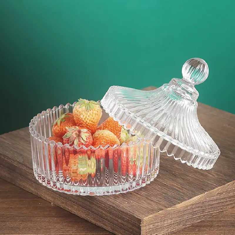Glass tea storage jar on wooden shelf with tea cups