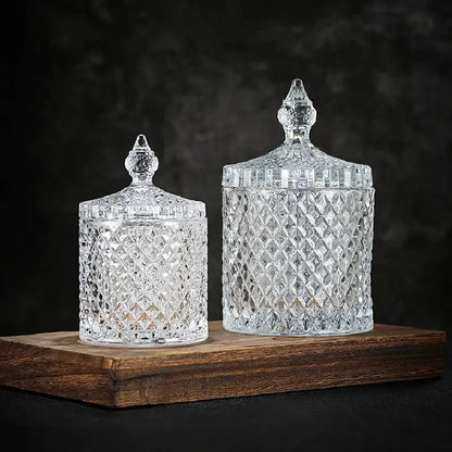 Clear crystal glass tea jar filled with loose leaf green tea, lid beside it