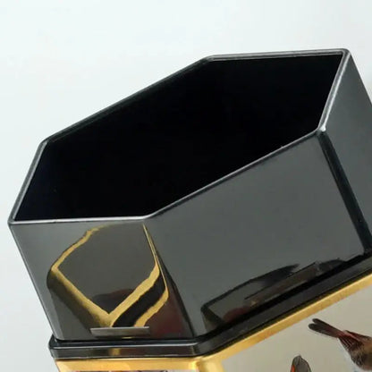 Open tea storage tin with loose leaf tea visible inside the canister