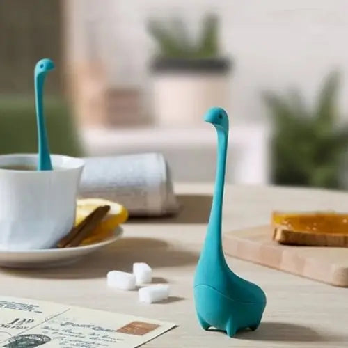 Diplodocus shaped tea infuser hanging on standard mug rim
