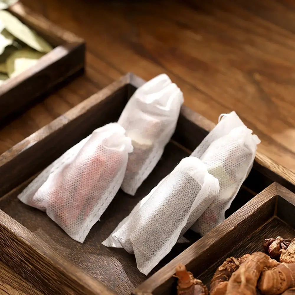 Drawstring loose leaf tea filter bag held over a ceramic mug, 8x10 cm size