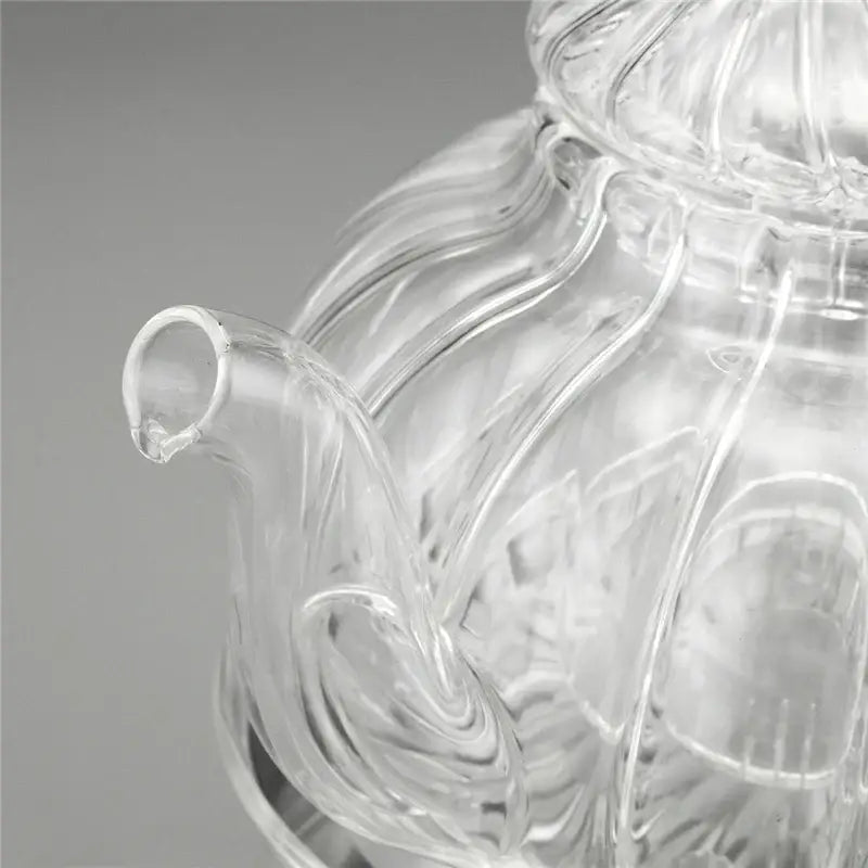 Complete glass teapot set with infuser, six cups and candle warmer, top-down view
