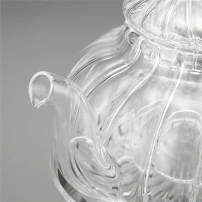 Complete glass teapot set with infuser, six cups and candle warmer, top-down view