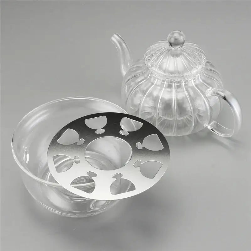 Tea-light candle warmer beneath glass teapot keeping tea at serving temperature