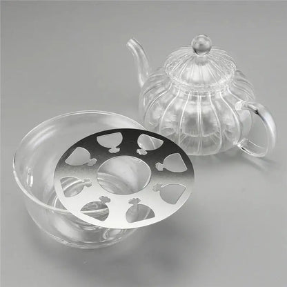Tea-light candle warmer beneath glass teapot keeping tea at serving temperature