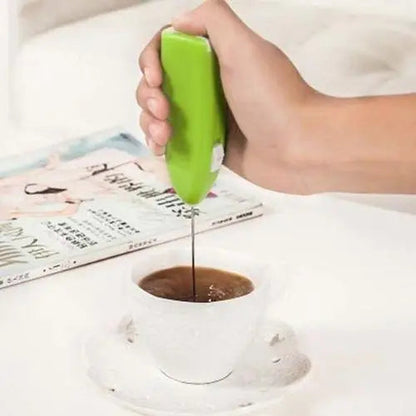 Battery-powered matcha frother beside a fresh green matcha cup