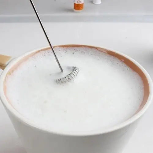 Cordless matcha frother frothing oat milk in a glass for latte