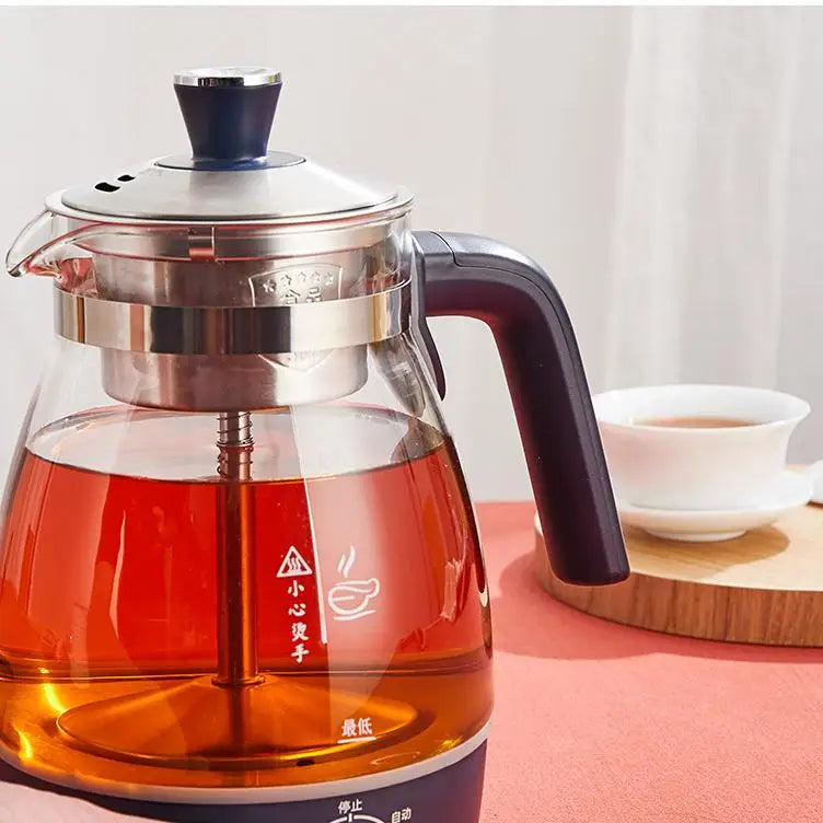 Electric tea infuser pouring hot tea into a cup
