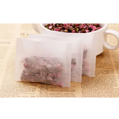 Empty tea bags laid out on a wooden table, natural light