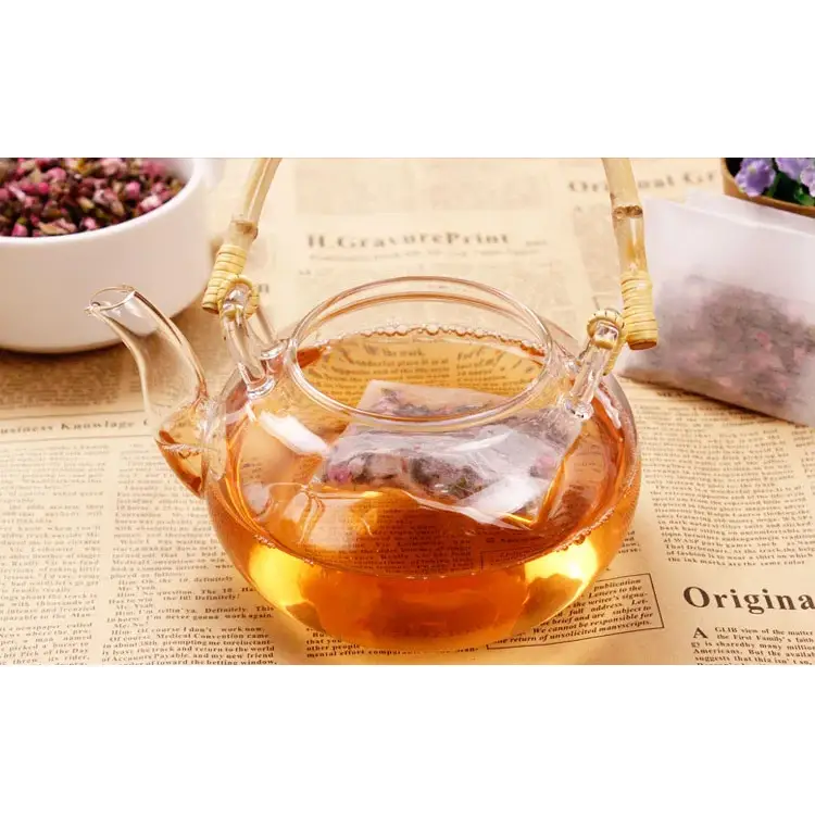 Tea bag with drawstring being filled with loose tea leaves
