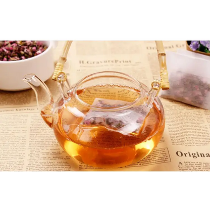 Tea bag with drawstring being filled with loose tea leaves