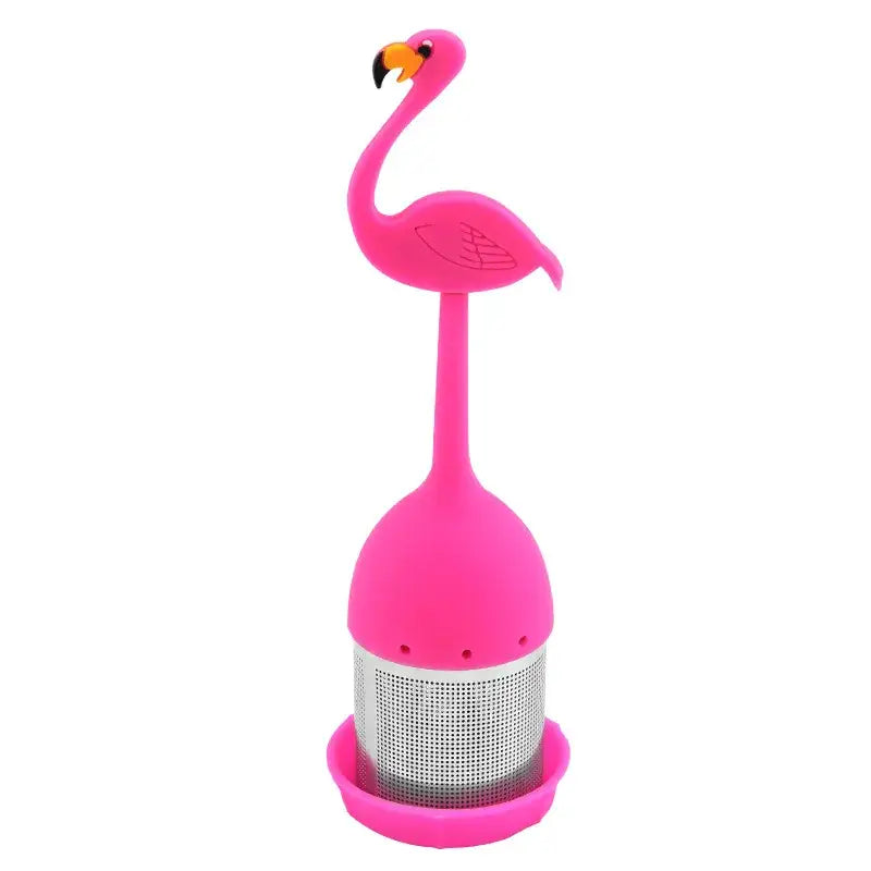 Flamingo tea infuser resting on a saucer with loose leaf tea