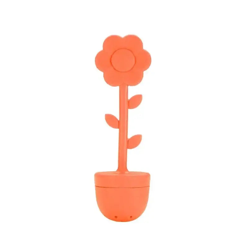 Orange flower tea infuser on a wooden table