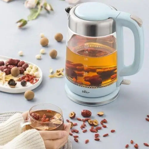 Transparent glass kettle glowing blue while boiling