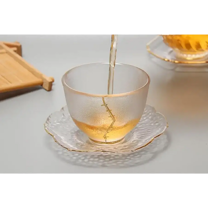 Clear glass saucer with a teacup and teapot