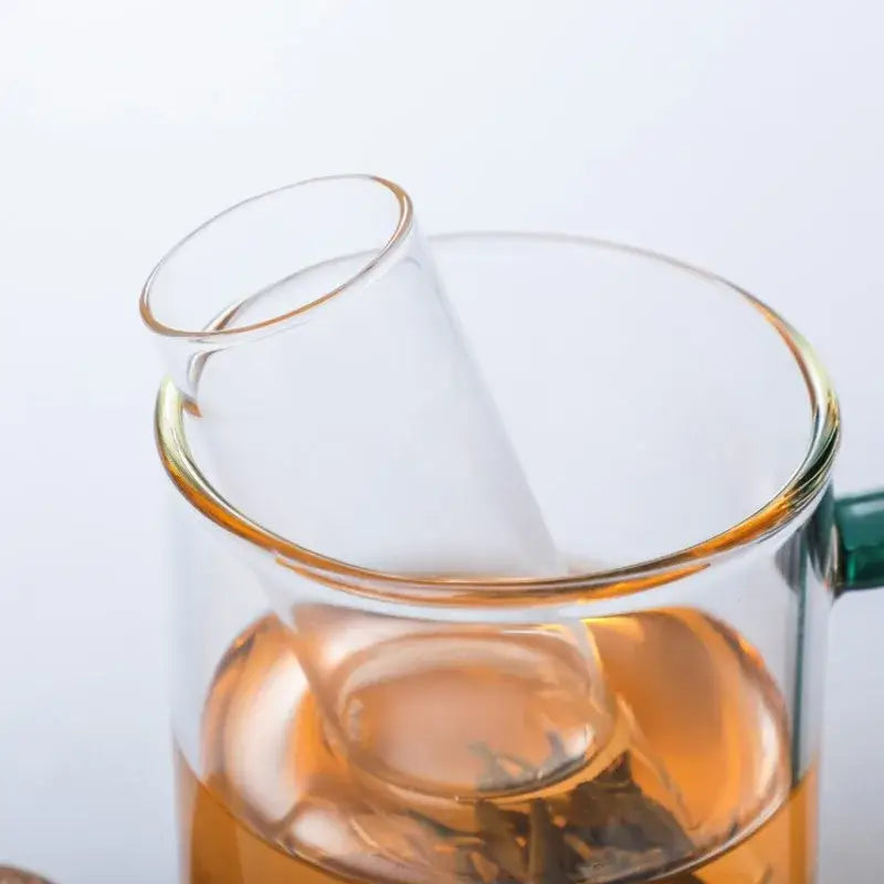 Glass tea infuser for loose leaf tea steeping in a ceramic mug