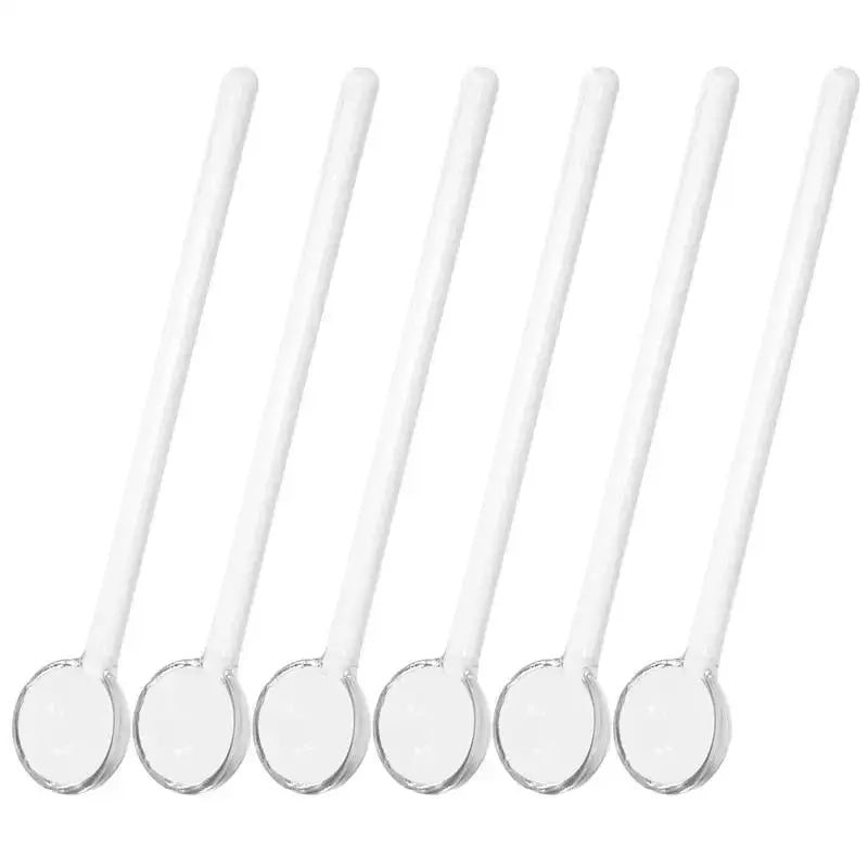 Three glass tea spoons arranged on a saucer