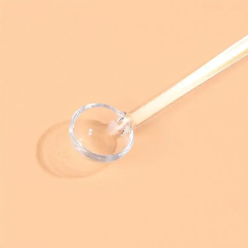 Close-up of a glass tea spoon stirring a cup of tea
