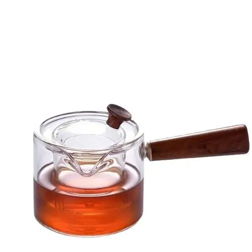 Clear glass teapot with loose leaf tea steeping inside