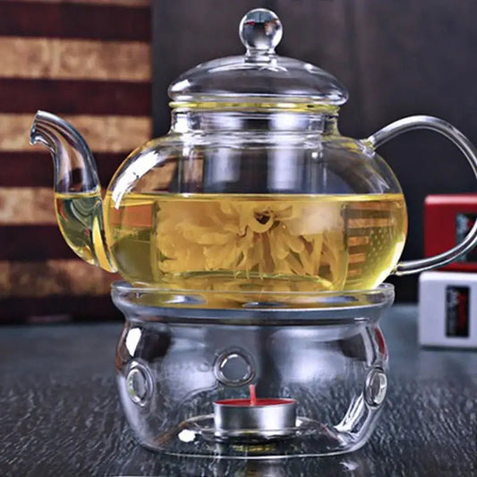 Glass teapot warmer with tea light candle lit inside holder