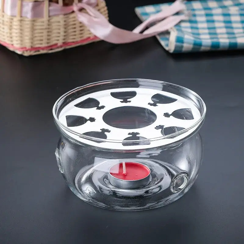 Clear borosilicate glass teapot warmer stand on wooden table