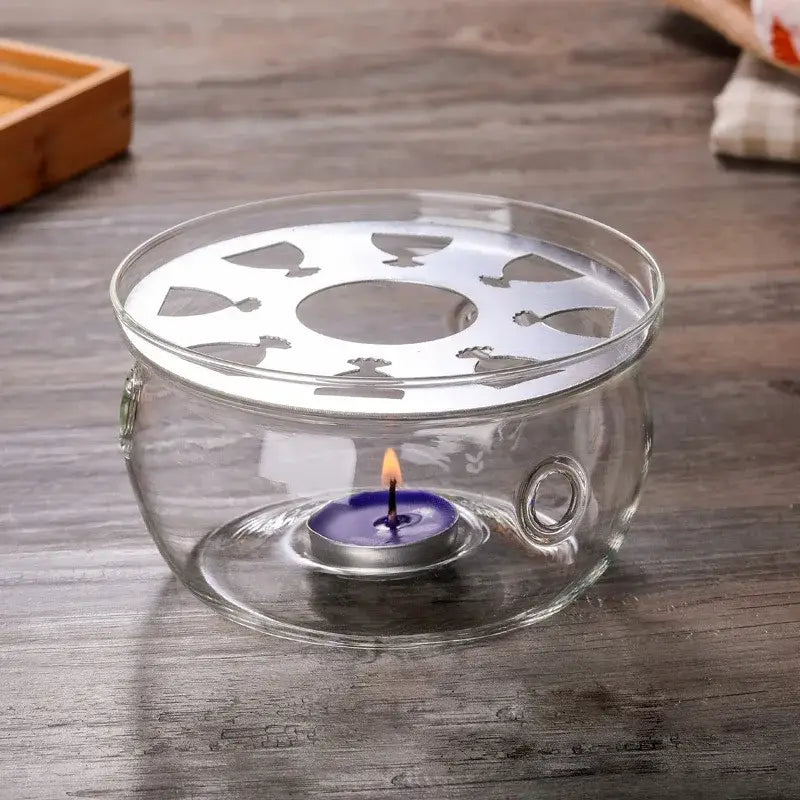Glass candle holder teapot warmer with tea light glowing underneath