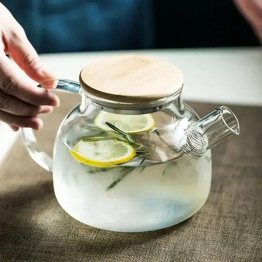 Transparent borosilicate glass teapot with loose leaf tea steeping inside the infuser basket