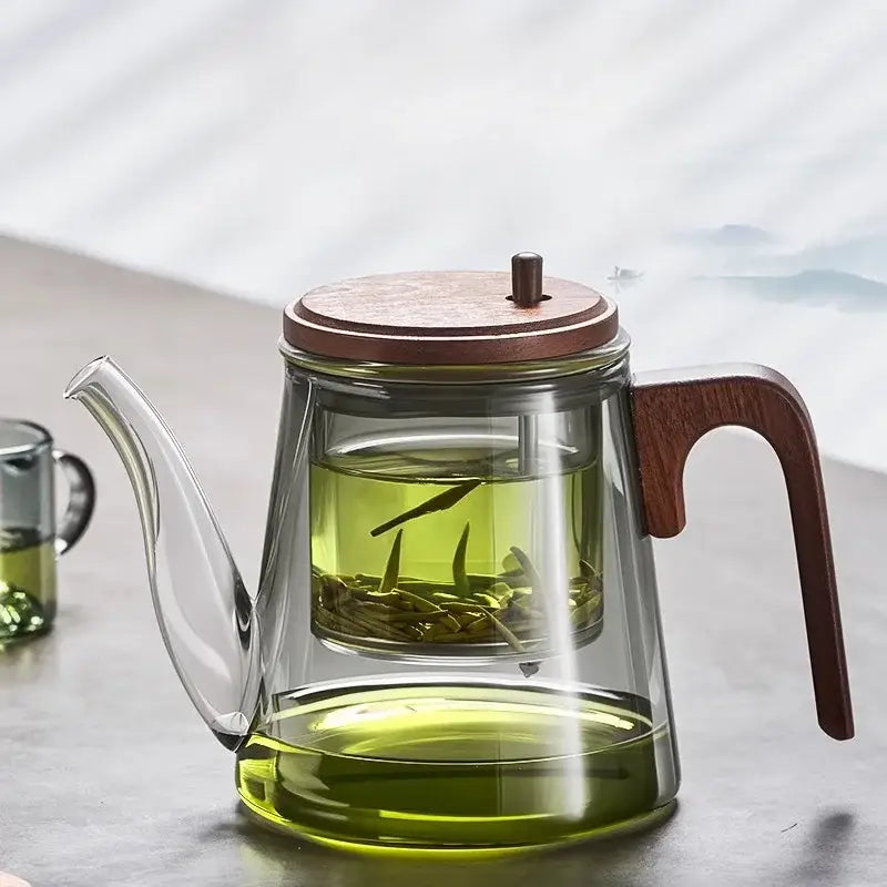 Glass teapot with infuser on wooden table