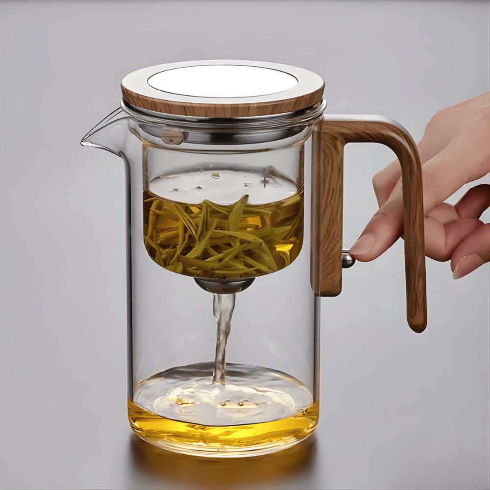 Glass teapot with stainless steel infuser basket in raised one-click position above the brew
