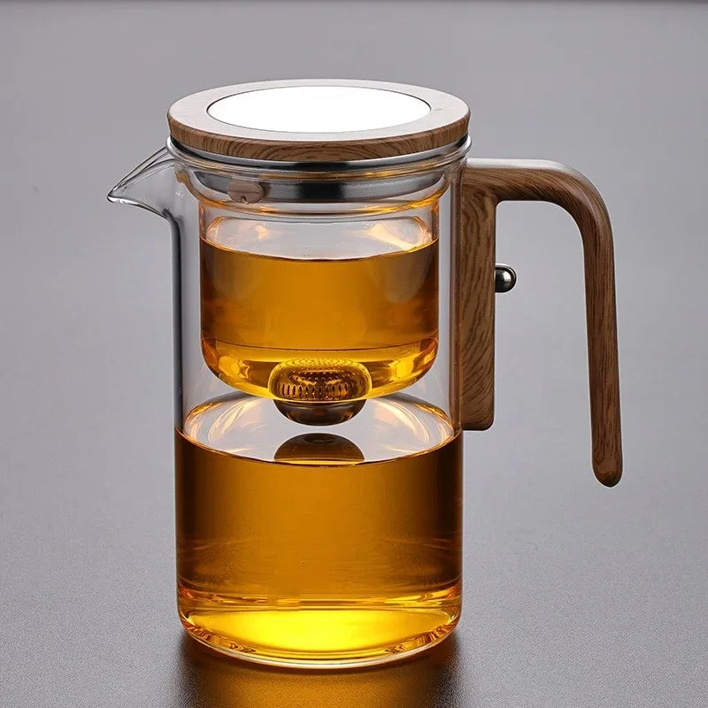 Side view of borosilicate glass teapot showing wooden handle and removable steel infuser
