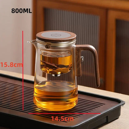 Glass teapot filled with amber-colored tea, infuser lifted by one-click separation button