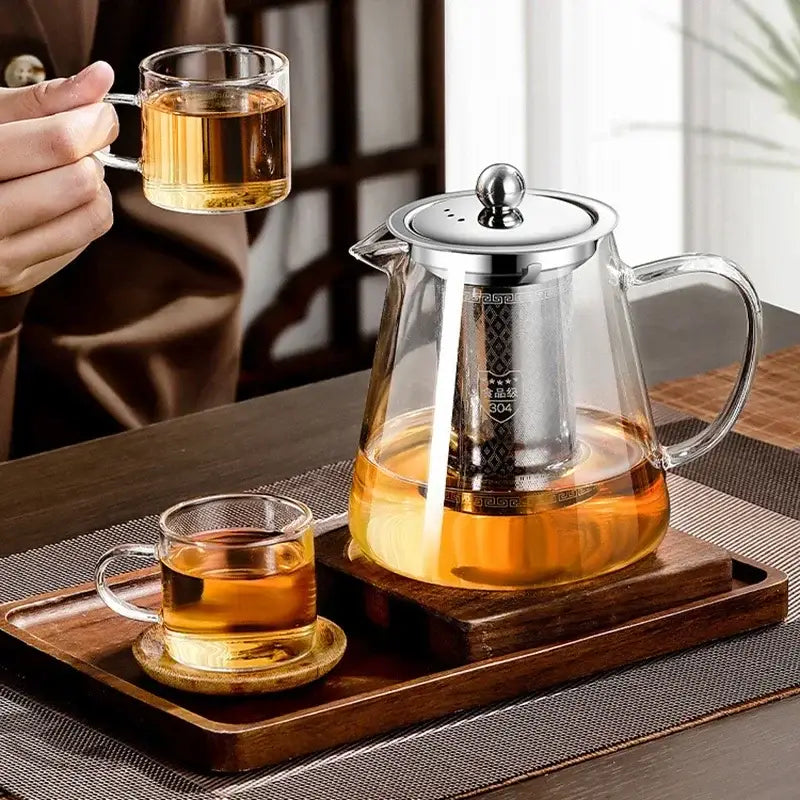 Glass teapot with stainless steel infuser on a wooden table