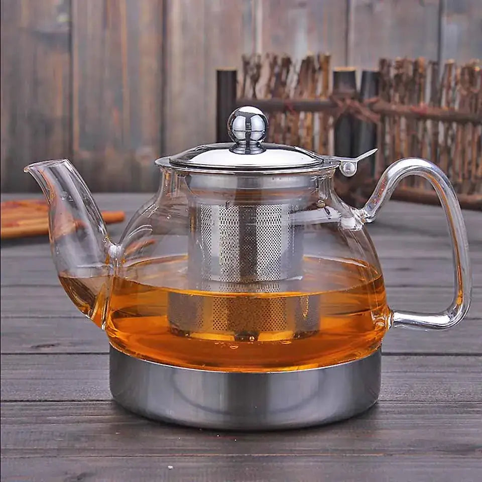 Borosilicate glass teapot sitting on induction cooktop burner with infuser inside